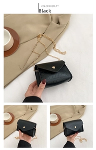 Detail of black crocodile pattern PU leather shoulder bag with gold chain and clasp