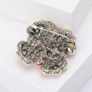 Close-up of golden vintage clover brooch showing sturdy pin back and textured alloy detail