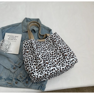 Sac fourre-tout léopard en toile avec veste en jean sur fond texturé blanc