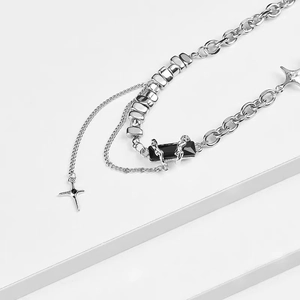 Close-up of multilayer silver titanium steel necklace with black gem and star charm