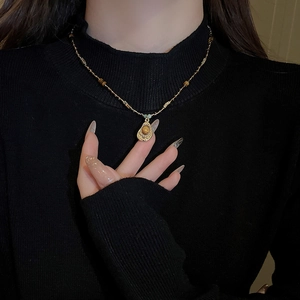 Gros plan d'un collier vintage avec pendentif en pierre oeil de tigre marron en goutte