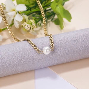 Elegant gold Cuban chain necklace featuring a white pearl pendant on a minimal backdrop