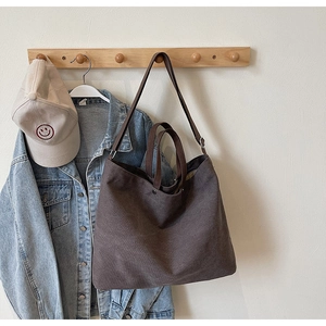 Detail of large brown canvas tote bag hanging with Japanese minimalist lifestyle styling