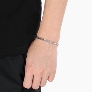 Silver stainless steel Cuban chain bracelet with geometric bar design on a model wrist