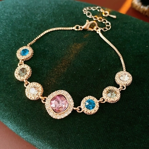 Macro detail of rose gold bracelet with colorful square and round crystal stones
