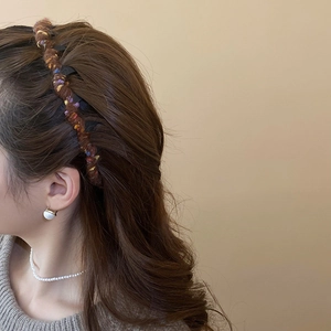 Detail of dark brown knitted headband with textured wool and colorful tweed weave pattern
