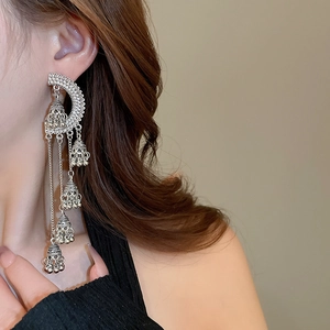 Détail de boucles d'oreilles Jhumka vintage argentées avec longs pompons à cloches