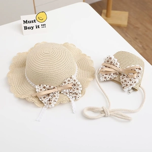 Close-up of kids straw hat and matching bag with floral bows and white lace trim
