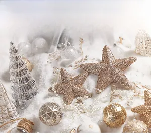 Detail of glittered star tree topper with gold ornaments and festive decor setup