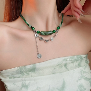 Vue détaillée du collier de perles chinoises vertes avec des pendentifs en pièces d'argent