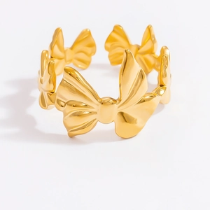 Macro view of gold bow-shaped open ring made of polished stainless steel for women