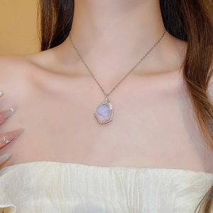 Detailed view of irregular lilac stone pendant with intricate wire wrapping on a model