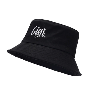 Classic black cotton bucket hat with white Gigi embroidery on a minimalist flat top design