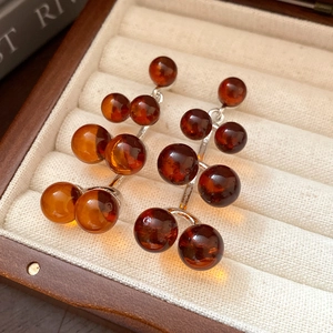 Macro detail of amber resin beaded drop earrings inside a velvet jewelry gift box