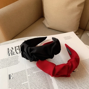 Gros plan de serre-têtes plissés en noir et rouge avec une étiquette faite à la main