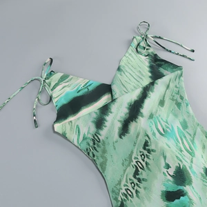 Dettaglio dell'abito in raso con stampa tie-dye verde e spalline sottili regolabili