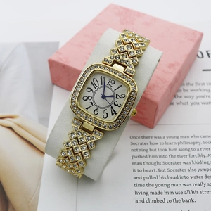Luxury gold women's watch with crystals and square dial on white pillow display