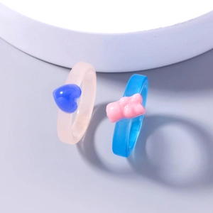 Cute pink heart and blue gummy bear resin rings set for women on light grey surface