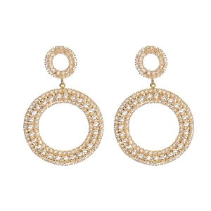 Détail de boucles d'oreilles double cercle dorées avec pavé de cristaux brillants