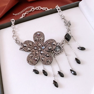 Détail du pendentif fleur vintage avec strass gris et gouttes en cristal noir