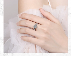 Close-up of a silver ring with a square zircon and hollowed band on a model