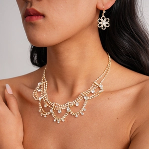 Detailed close-up of luxury gold teardrop lace necklace and floral earrings set