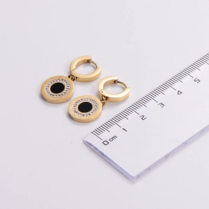 Detail view of gold Roman numeral earrings with measurement ruler for scale