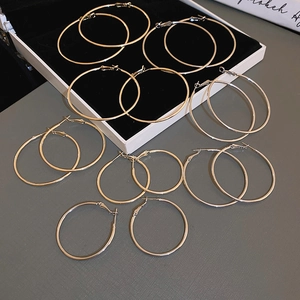 Multiple sizes of minimalist gold and silver hoop earrings displayed in a jewelry box