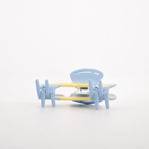 Close-up of light blue and yellow acetate hair claw clip showing metal spring detail
