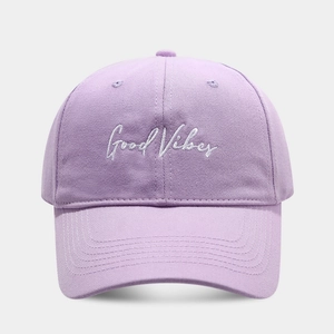Close-up of Good Vibes white script embroidery on light purple cotton baseball cap