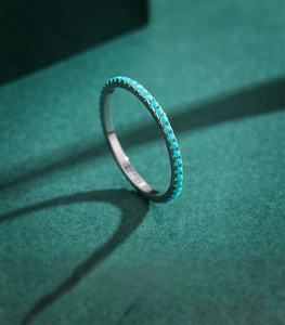 Macro shot of S925 sterling silver ring with blue turquoise stones on green velvet