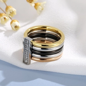 Detail of multi-layer mixed metal ring with sparkling zircon insets on textured fabric