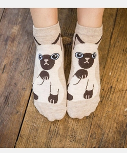 Close-up of Japanese style cotton ankle socks with cute Siamese cat pattern on wood background