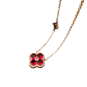 Golden clover pendant necklace with red stone, white zircon accents and butterfly charm