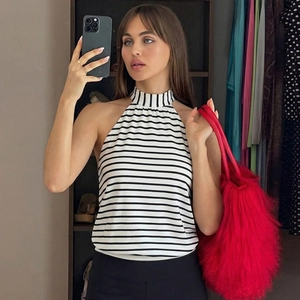Detail of knit halter top with black and white stripes and red faux fur handbag