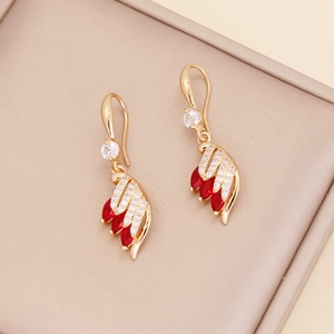 Detail of golden wing earrings with red marquise gems and crystals in a jewelry box