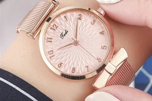 Dettaglio orologio da donna oro rosa con quadrante rosa testurizzato e cinturino milanese