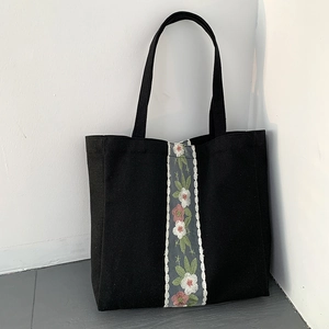 Borsa tote nera in tela con ricami floreali colorati e finiture in pizzo bianco elegante