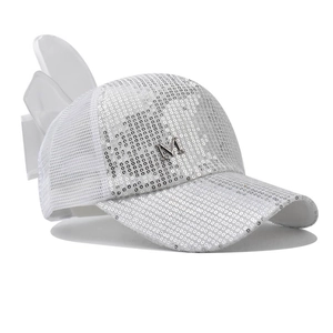 Détail de la casquette blanche à paillettes avec logo M argenté et grand nœud satin