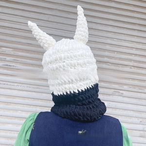 Detail of handmade knit balaclava with devil horns and black-white contrast design