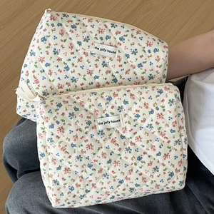 Macro detail of quilted corduroy makeup bag with floral patterns and zipper closure