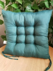 Detail view of teal quilted chair pad with nine-point stitching and secure ties