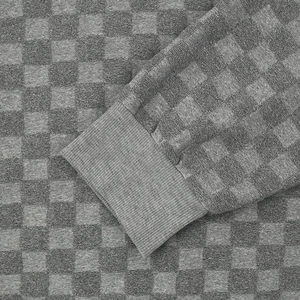 Close-up of gray checkerboard jacquard knit fabric with ribbed cuff detail