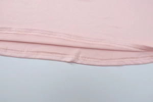 Detail shot of pink dress hem featuring professional double-needle stitching and knit fabric