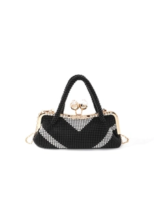 Close-up of black and white beaded clutch with golden metal frame and crystal clasp