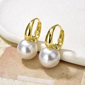 Elegant gold hoop earrings with white round pearls in a minimalist aesthetic