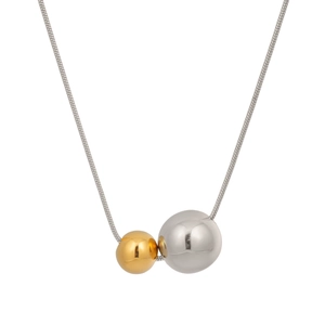 Macro detail of bicolored gold and silver beads on a high-gloss snake chain necklace
