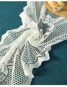 Close-up detail of white lace fabric texture on dark blue background for table decor