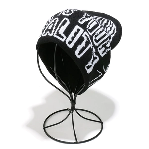 Detail view of black knit beanie with white jacquard letters on high-quality fabric