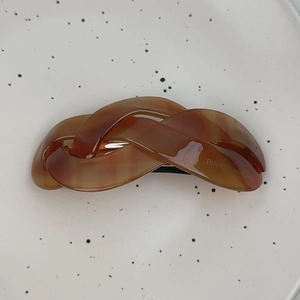 Close-up of France Handmade engraving on brown amber resin twist hair clip